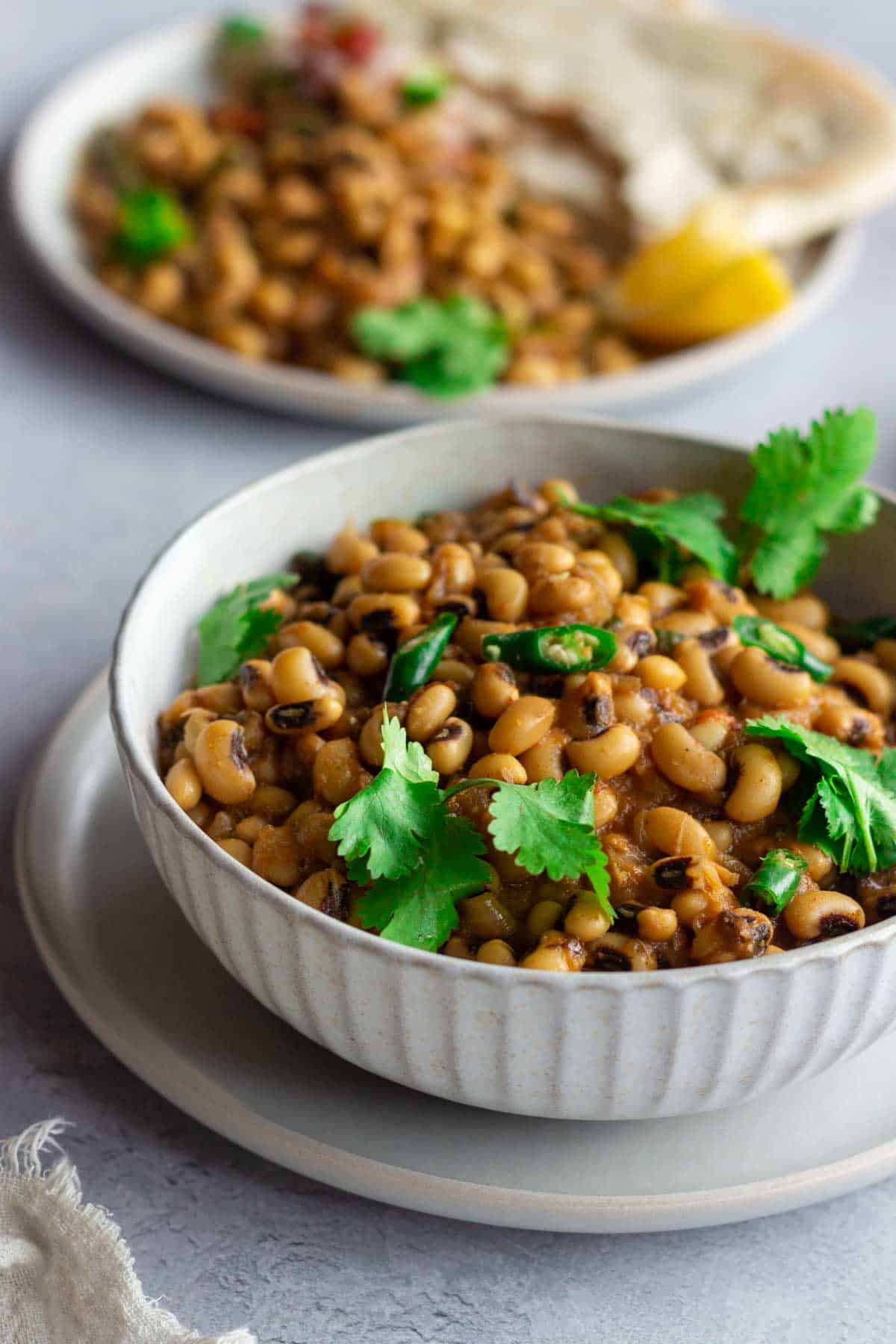 A bowl of lobia or black eyed peas curry on top of a plate.