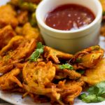 Onion pakora, pyaz pakora or onion fritters are a Pakistani / Indian appetizer made with sliced onion and coriander coated with a spicy chickpea flour batter and  deep-fried till crispy.