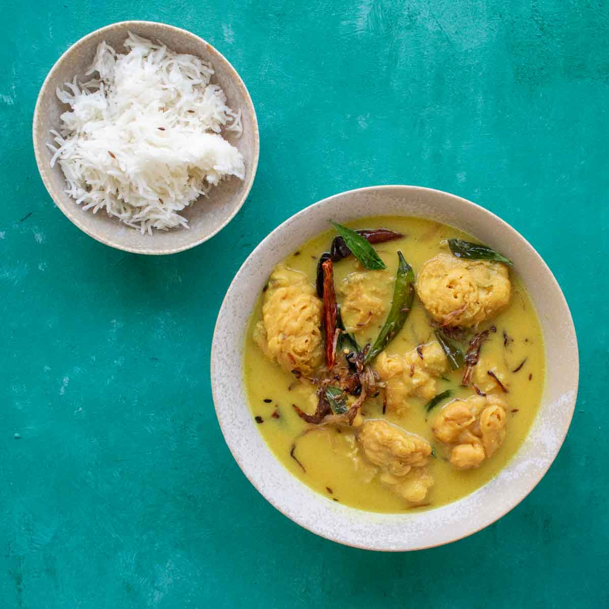 A bowl of pakora karhi with a bowl of rice.