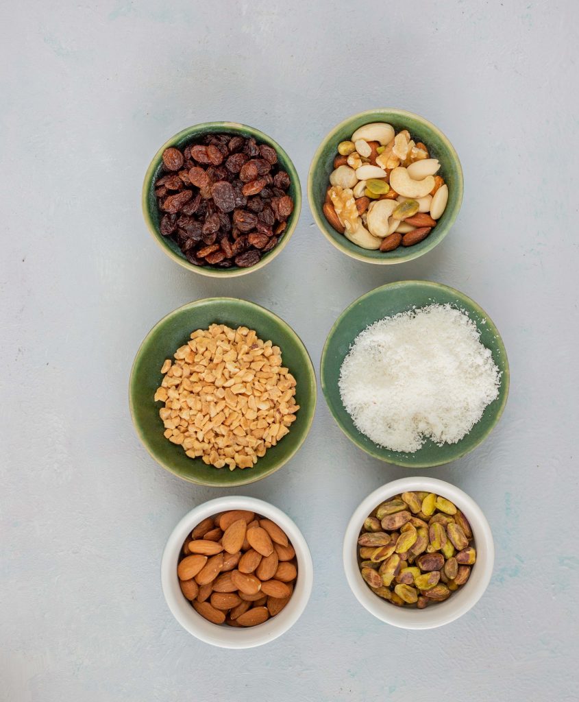 Different types of nuts used in a Desi Pakistani kitchen. Items include raisins, pistachios, almonds, peanuts and coconut. 