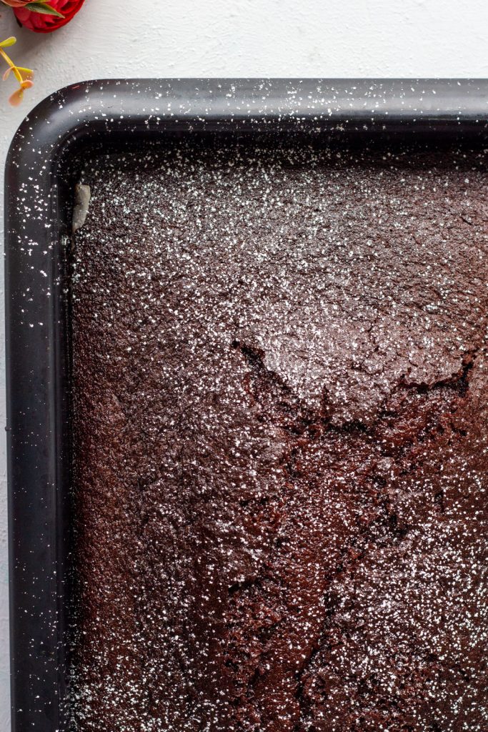 A quarter of a one bowl chocolate cake in a rectangle baking tray.