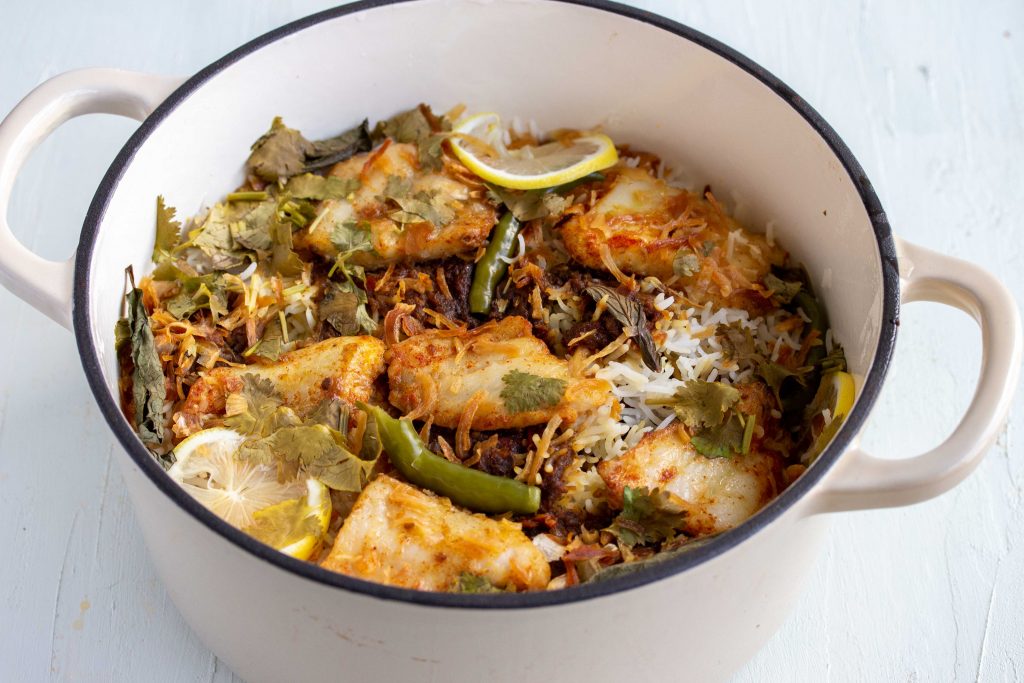 A Dutch oven cast iron pot with boneless fish biryani in the Pakistani style in it.