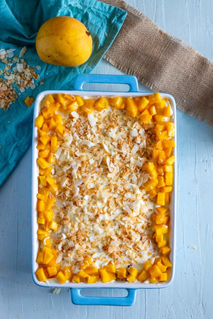 Mango coconut trifle or mango coconut layered dessert in a blue dish.
